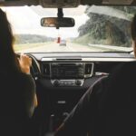 View from inside a car showing passengers looking out at an open highway, emphasizing travel and journey.